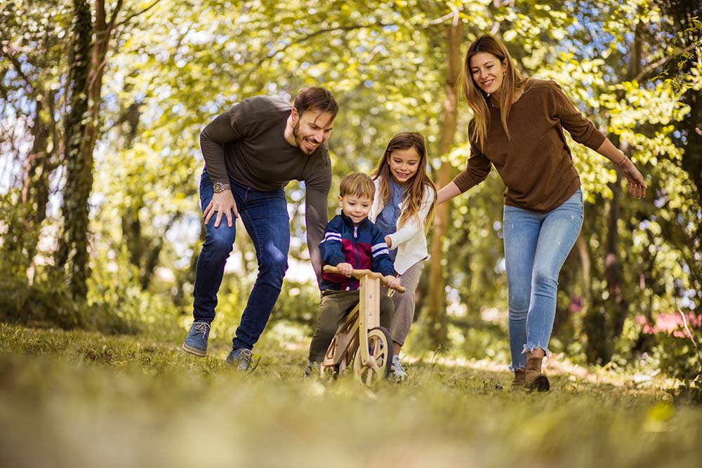 Happy family playing with small children outdoors