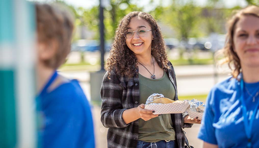 Young professional BCBSND employee smiling at company event.