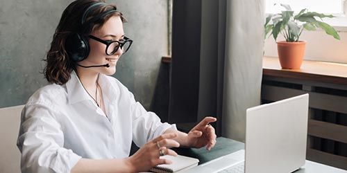 Young woman participating in online session with a laptop