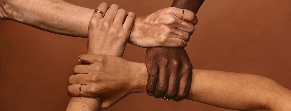 Four hands clasping each other