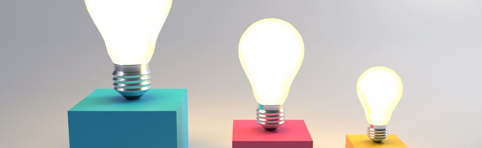 Three glowing light bulbs on top of colorful blocks